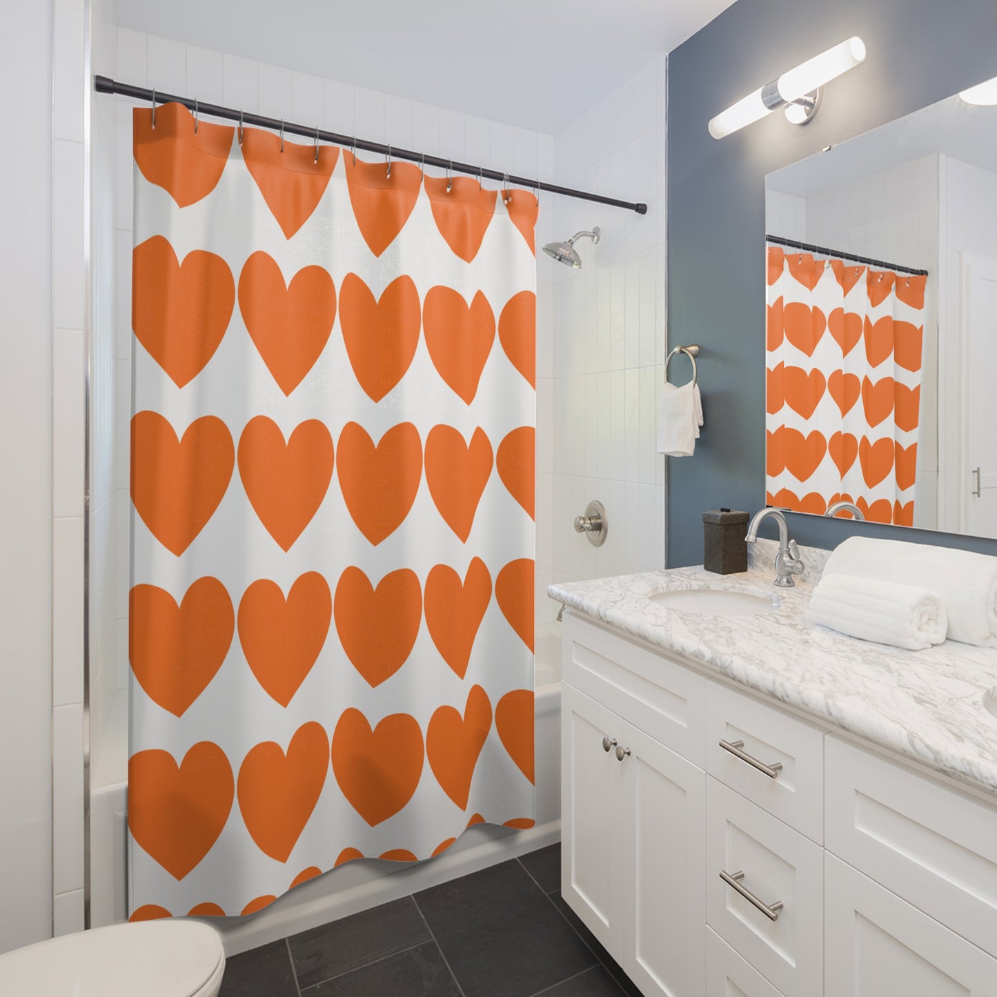 Styled bathroom scene with orange hearts shower curtain, colorful accents, and Pride-themed decor