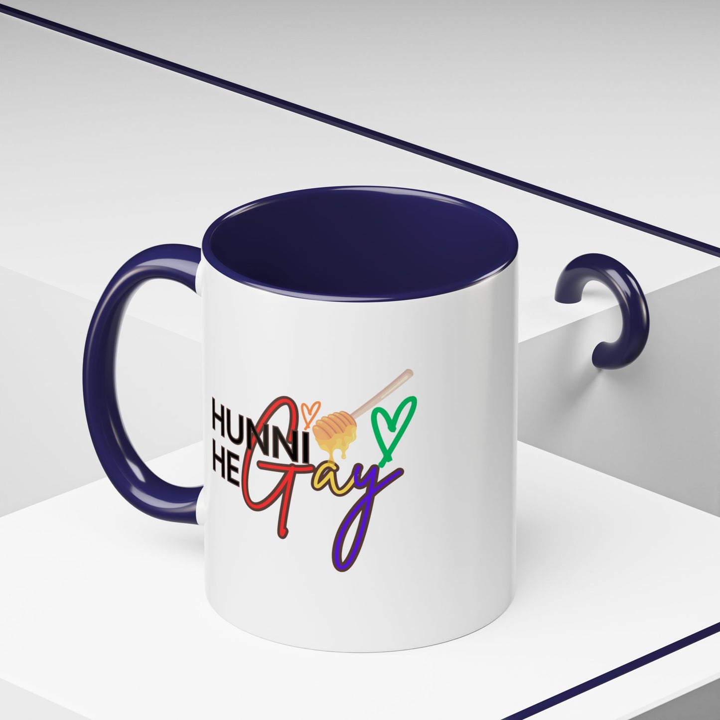 Glossy ceramic coffee cup showcasing "Hunni He Gay" in colorful typography, accented with a deep purple handle and rim to amplify its fierce, celebratory energy.