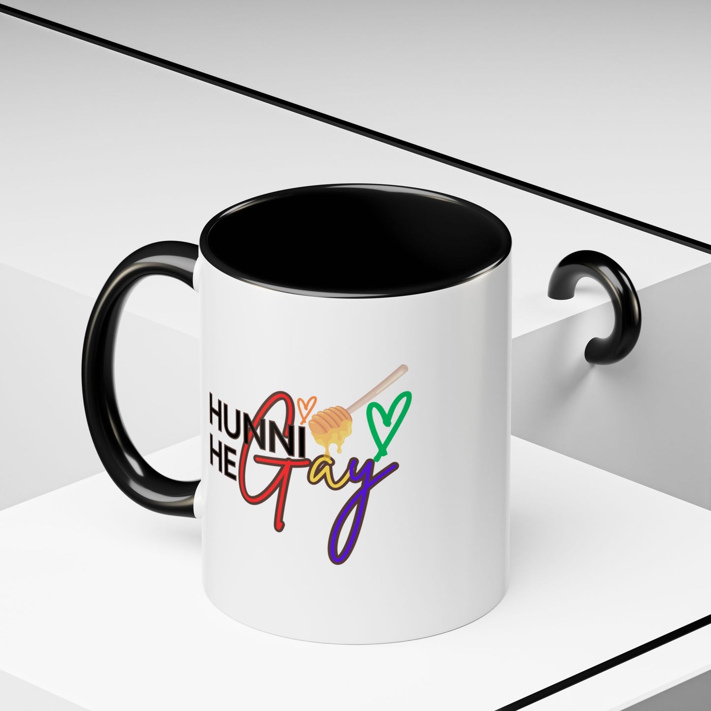 Sleek white ceramic coffee mug featuring "Hunni He Gay" in bold rainbow lettering, contrasted with a striking black handle and rim for a modern Pride aesthetic.