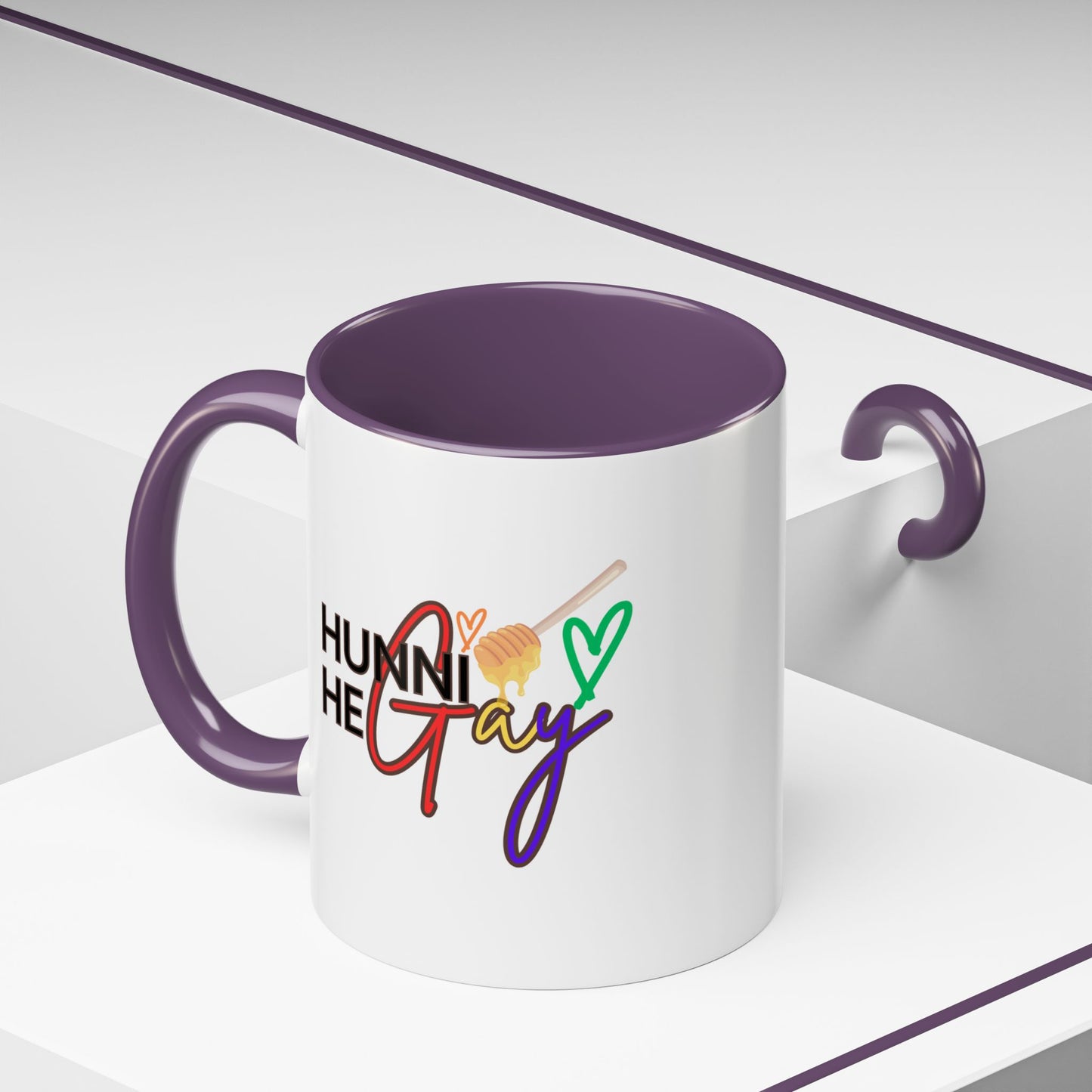 Glossy Pride mug featuring "Hunni He Gay" in a retro font, set against a rainbow backdrop with a deep purple interior and handle for extra flair.