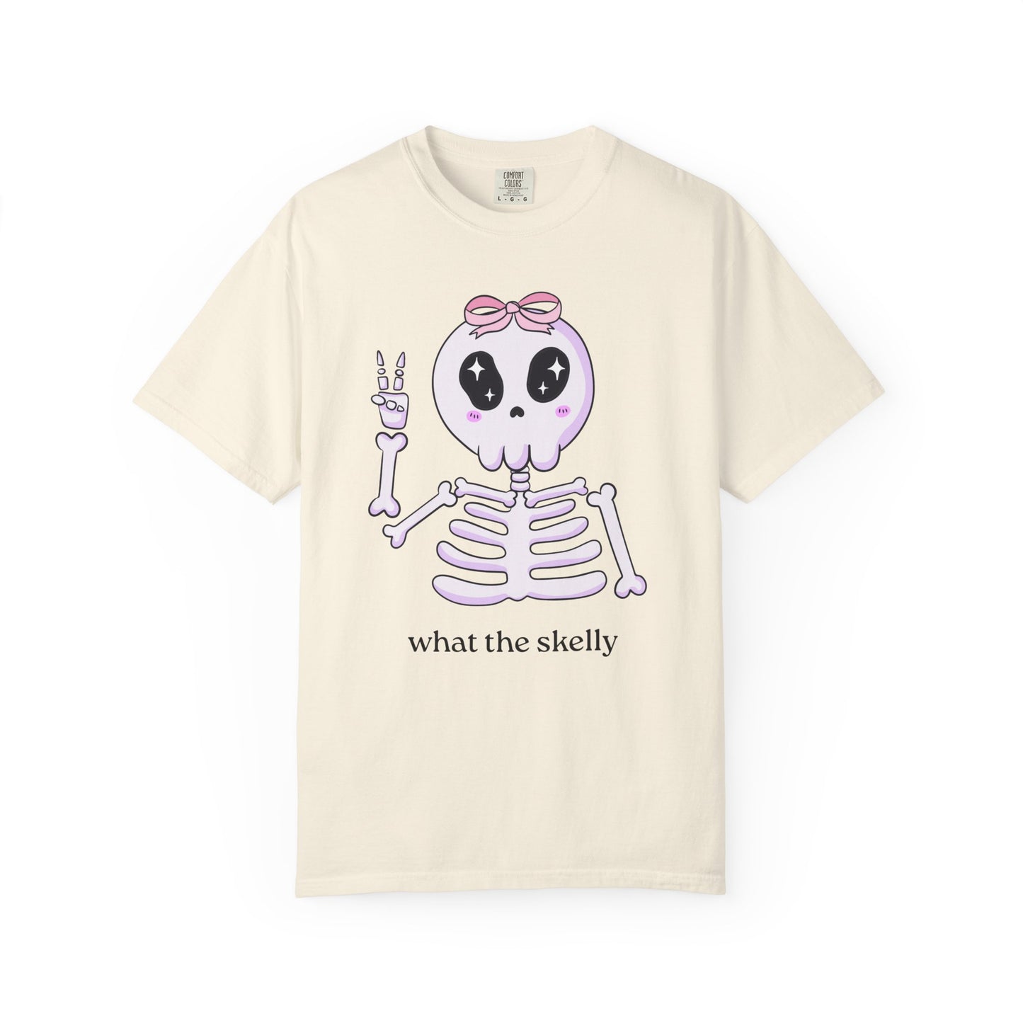 Ivory tee with “What the Skelly” skeleton graphic, styled for soft and spooky fall fashion.