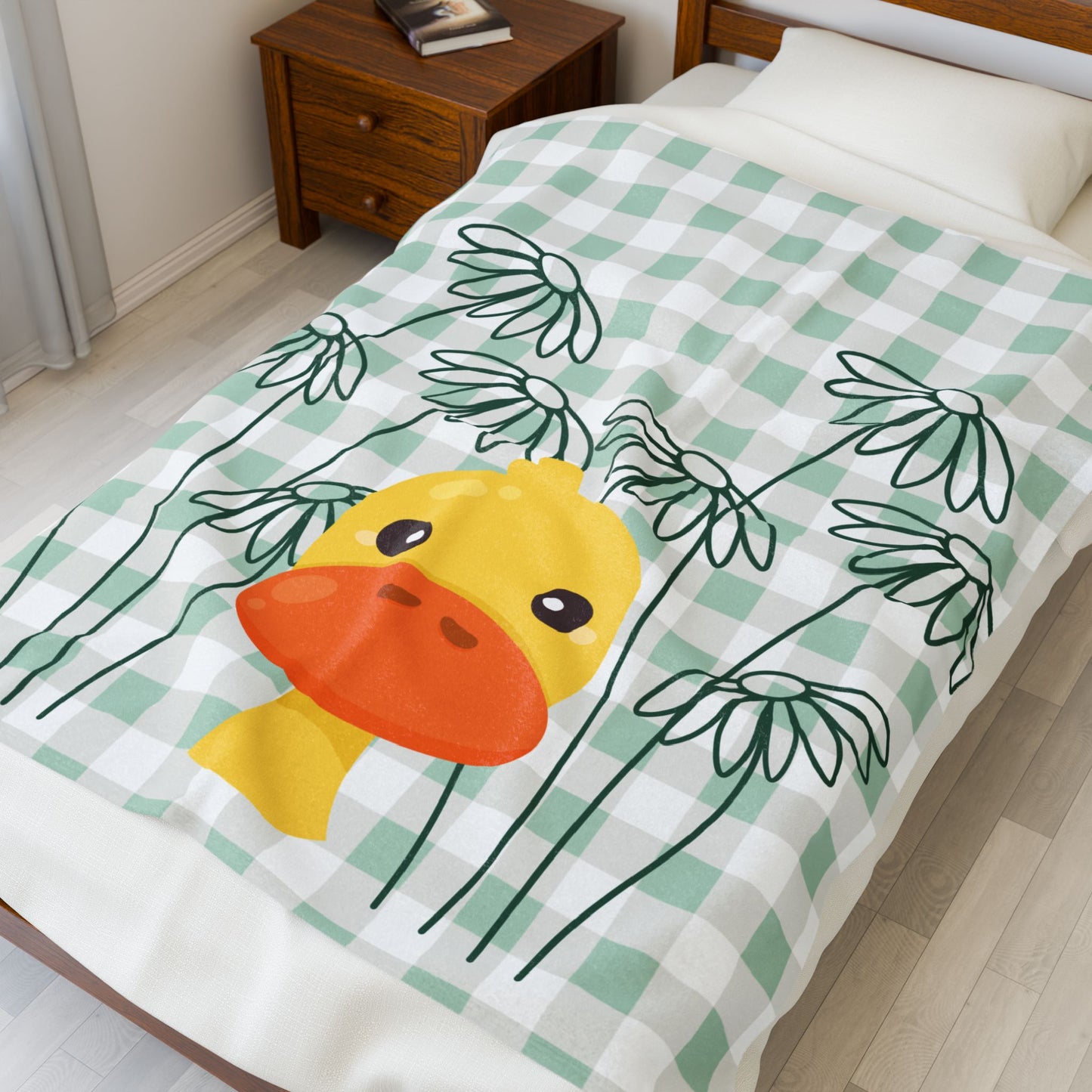 Folded plush throw blanket featuring cottagecore gingham with ducks and floral details in pastel tones