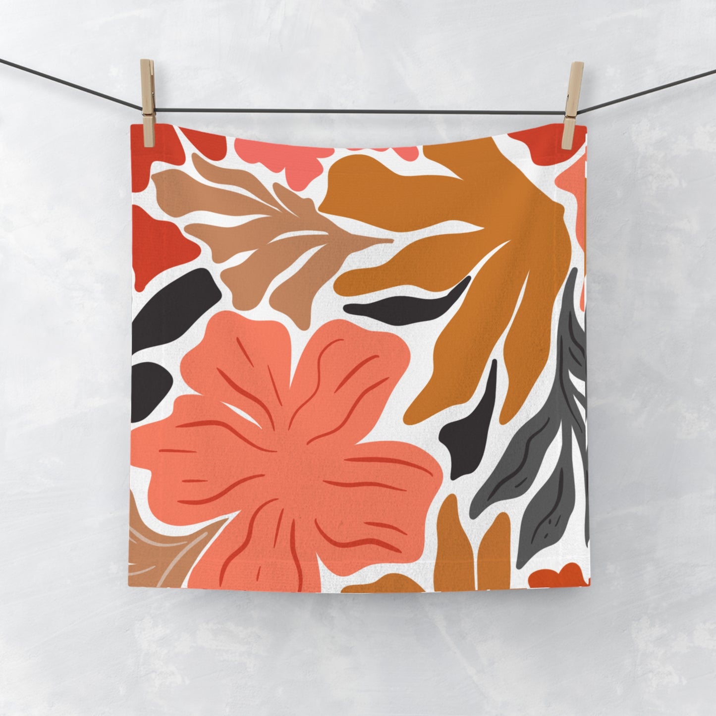 Orange floral towel on black background, laid flat with bold patter