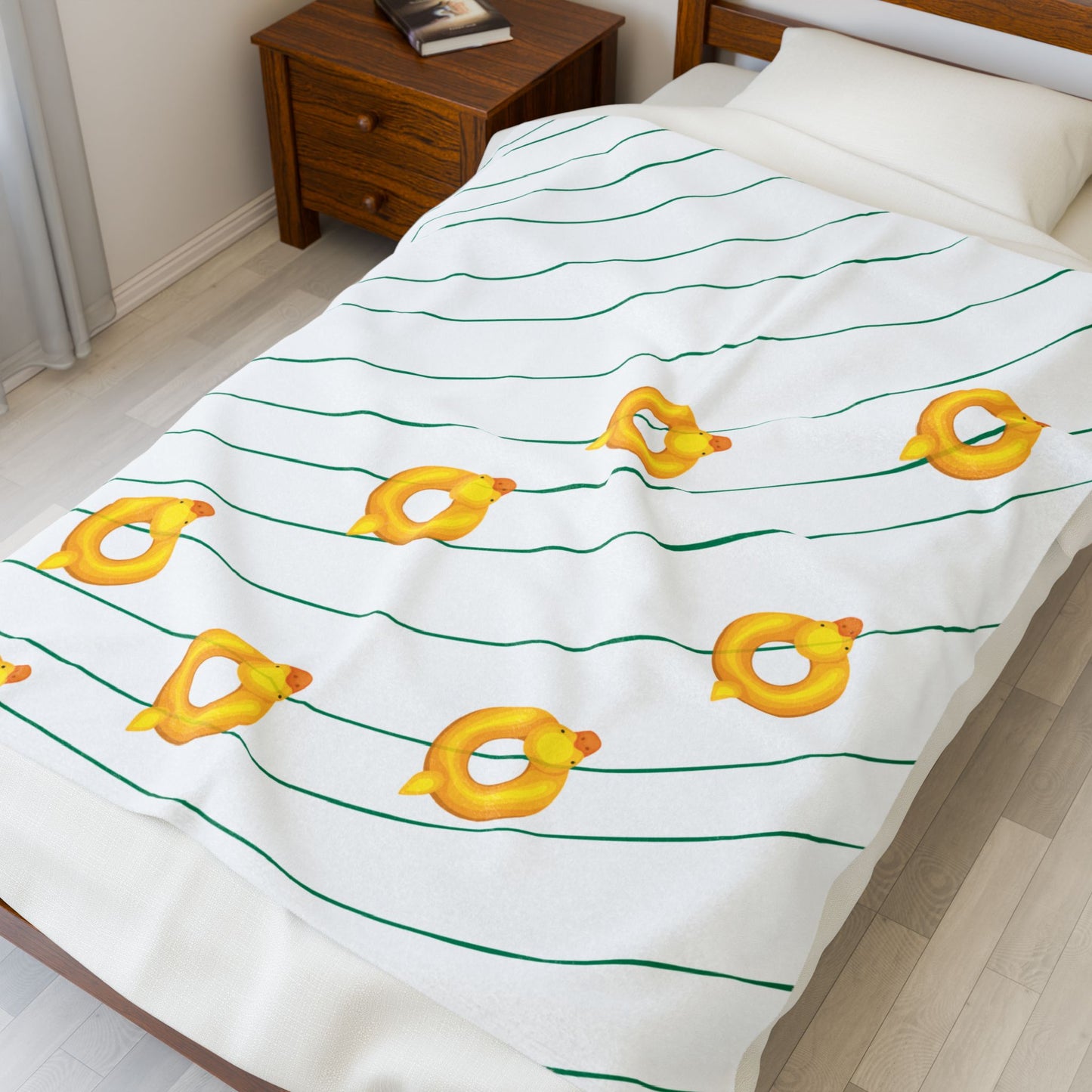 Rubber duckie-themed blanket folded on bed, soft plush for cozy dorm spaces