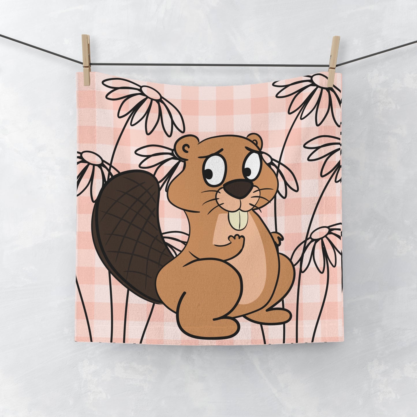 Soft orange gingham face towel with subtle beaver motif, laid flat on white surface