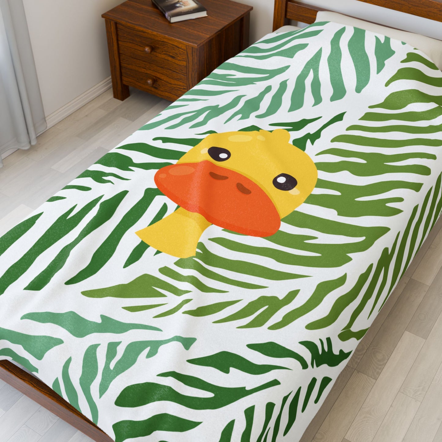 Close-up of soft blanket texture and whimsical duck jungle pattern
