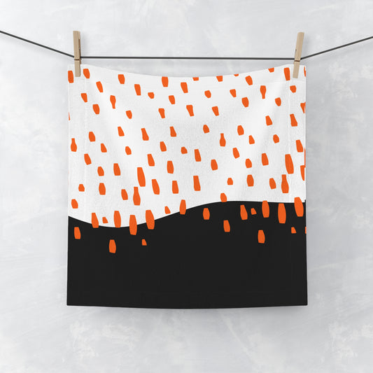 Black face towel with orange rain pattern, laid flat on white backgroun