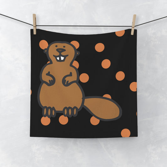 Black and orange polka dot hand towel with subtle beaver motif, laid flat on white surface