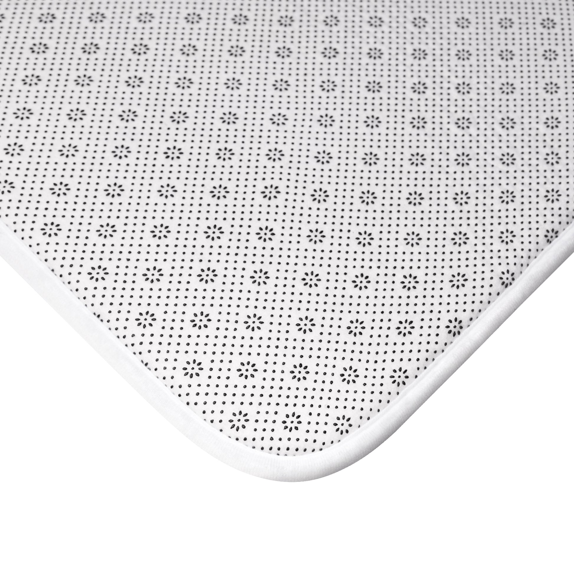 Close-up of plush bath mat with bold botanical pattern in yellow and green