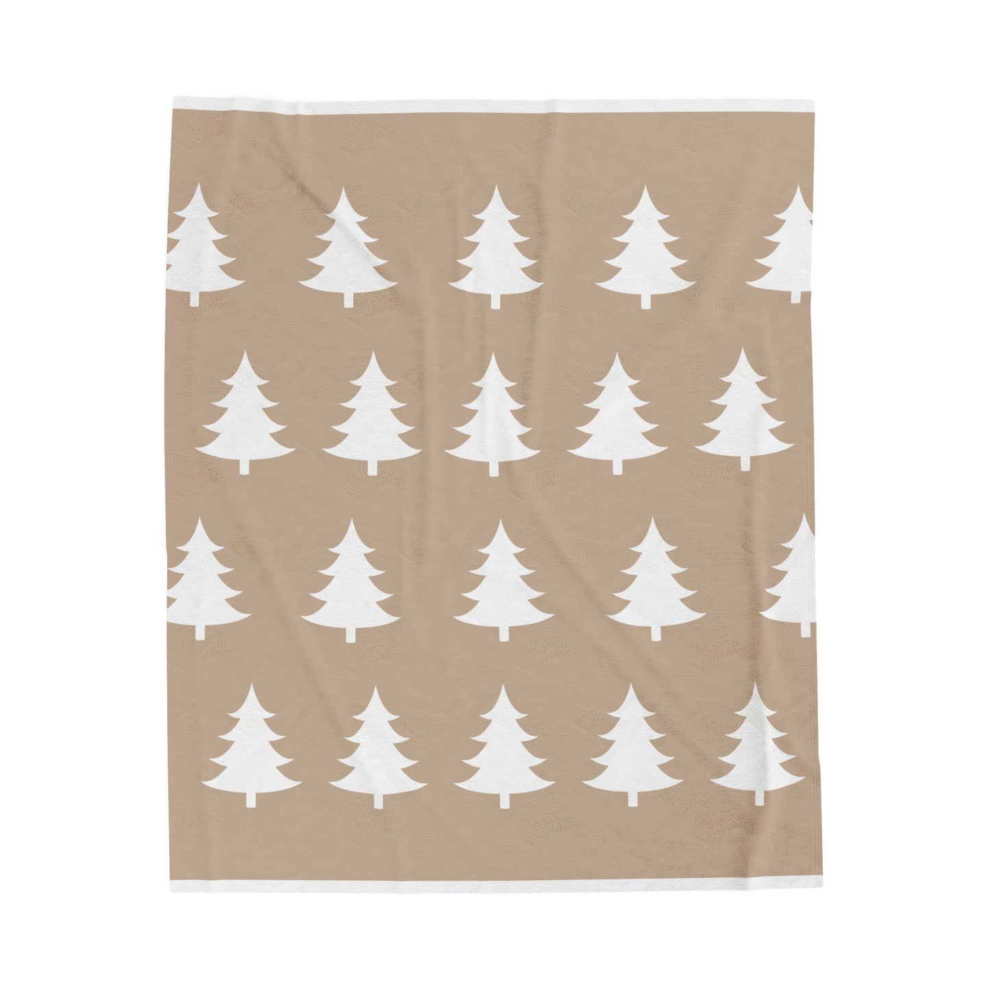 Flat lay of cozy holiday blanket featuring rustic tree motif on light brown fabric with warm winter accents"