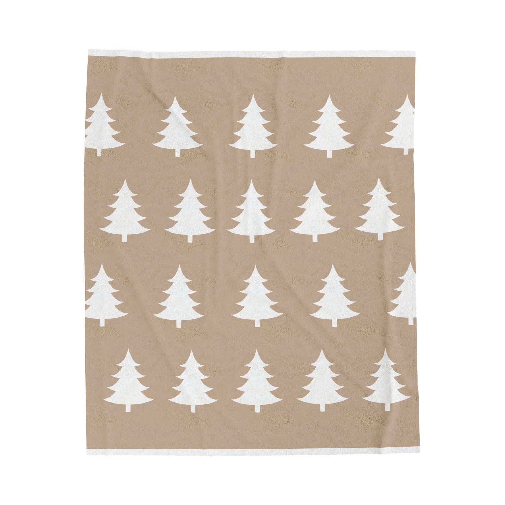 Flat lay of cozy holiday blanket featuring rustic tree motif on light brown fabric with warm winter accents"