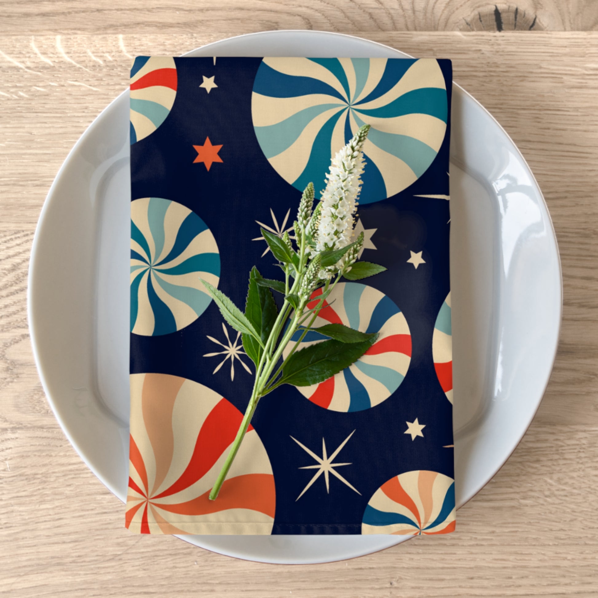 dark blue candy cane napkin styled on holiday plate with evergreen and red table accents