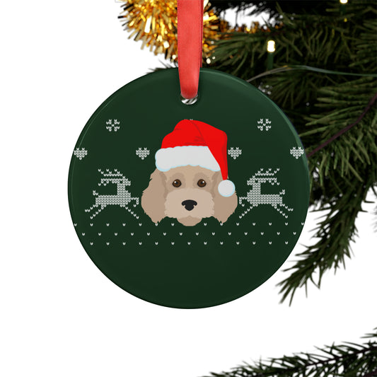 cockapoo Christmas ornament wearing Santa hat hanging on a decorated pine tree branch with twinkling holiday lights
