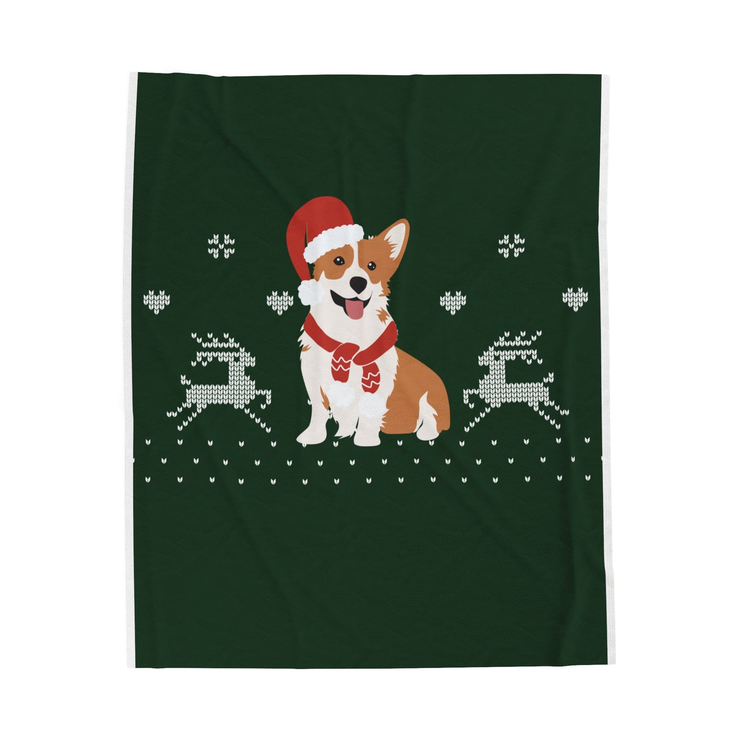 Flat lay of Christmas blanket with Santa-hat corgi design folded on soft surface surrounded by festive holiday decor