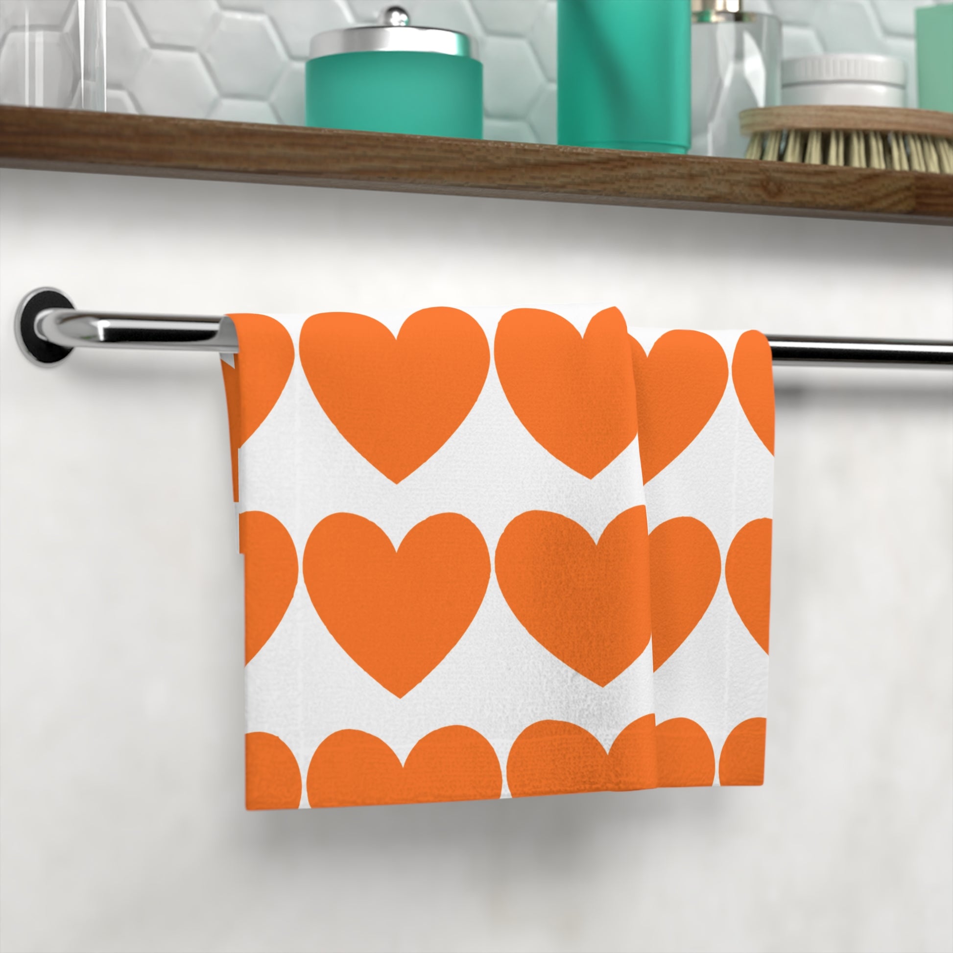Orange hearts towel styled in cozy bathroom with Pride-themed decor and natural light