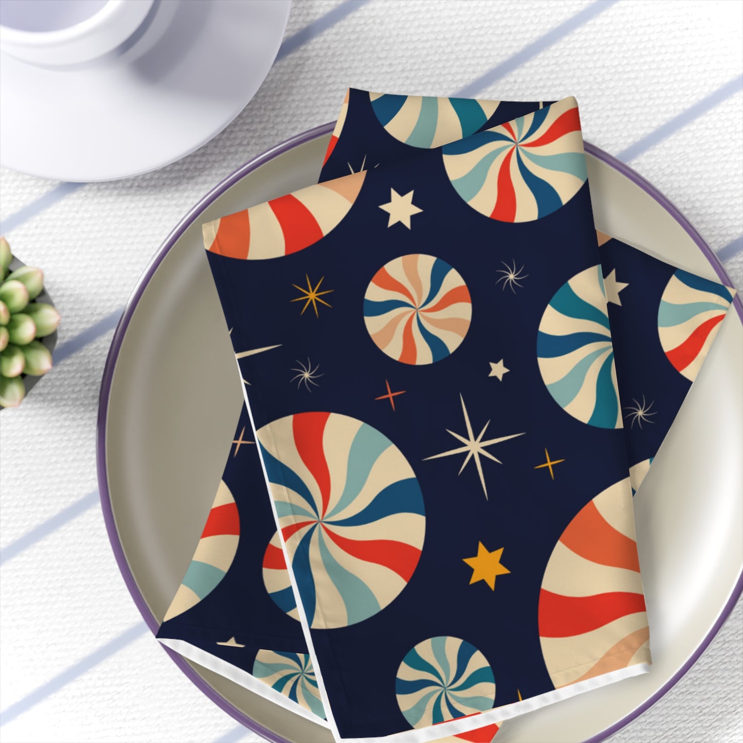 bold dark blue linen napkin with red and white candy cane print folded on festive table