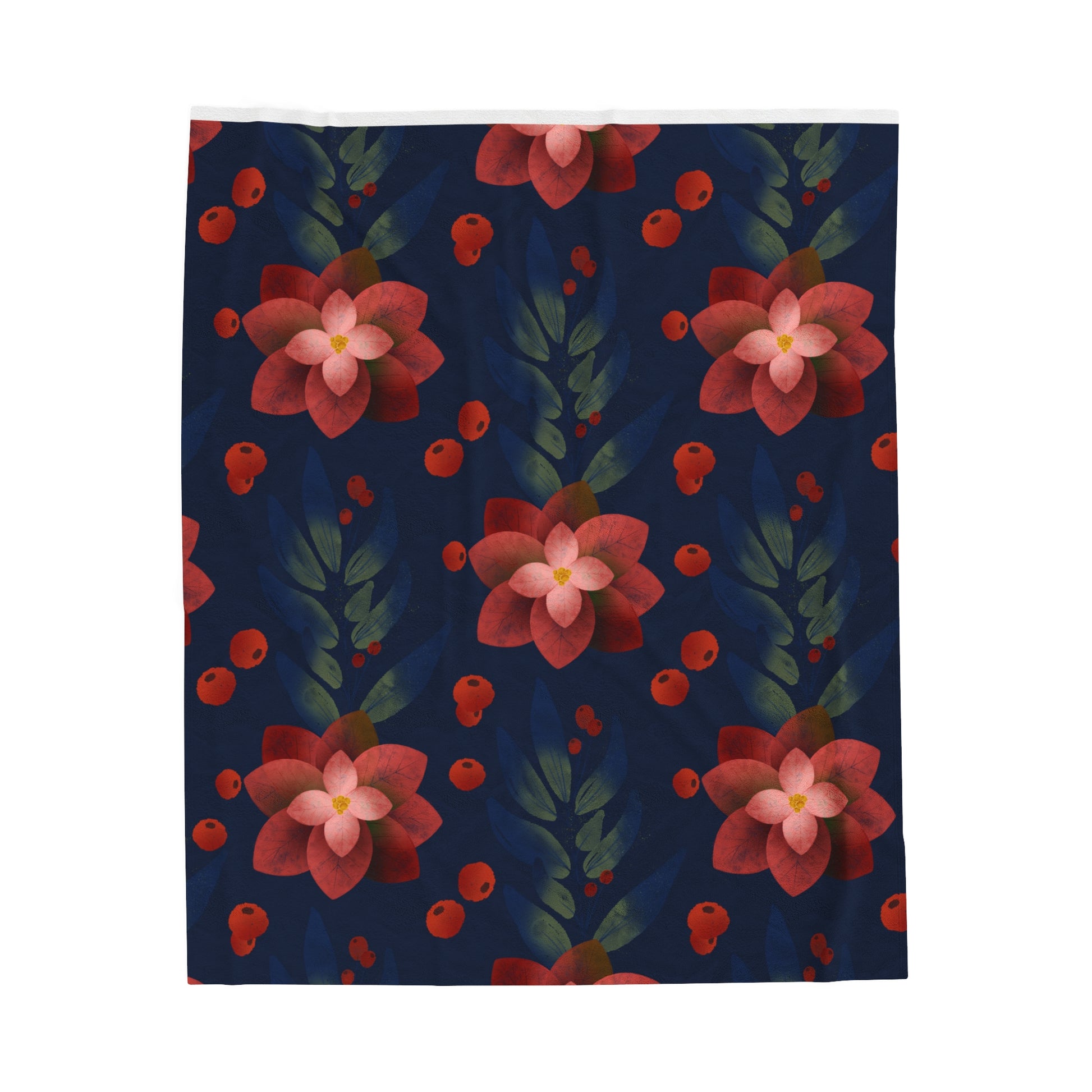 Flat lay of dark blue holiday blanket featuring silver poinsettia pattern folded neatly on cozy surface with festive accents