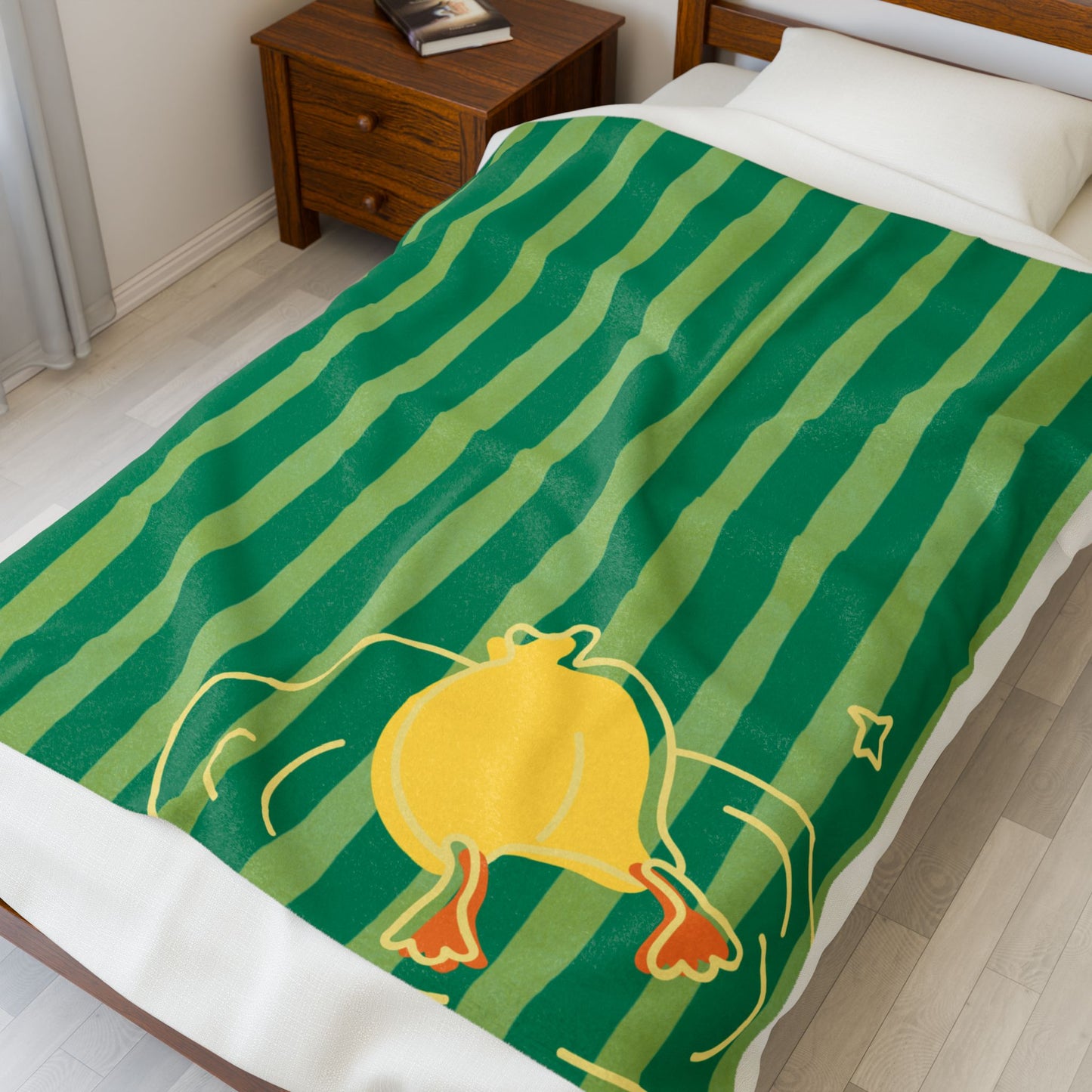 Folded plush blanket featuring green and yellow stripes and playful duck dive pattern for dorm-style decor