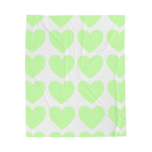 Folded mint green blanket with heart print for self-care dorm vibes