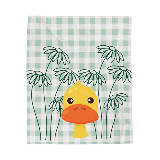 Light green plush blanket with gingham pattern, daisy accents, and duck print styled on cozy dorm bedding