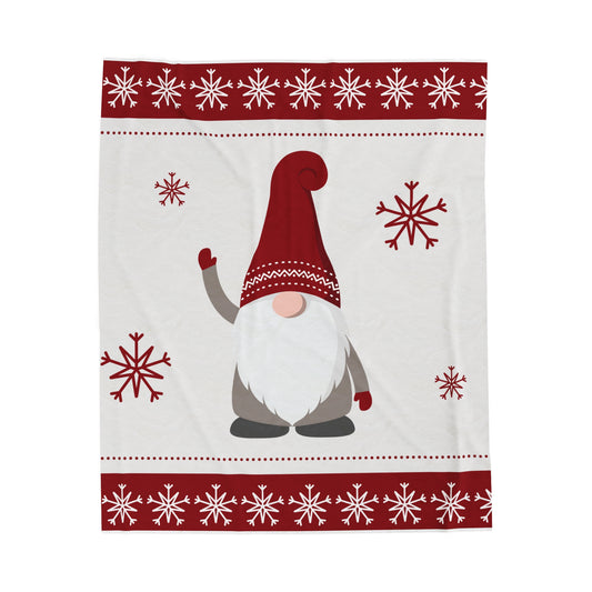 Flat lay of cozy red and white holiday blanket with playful gnome print on soft fleece or sherpa fabric