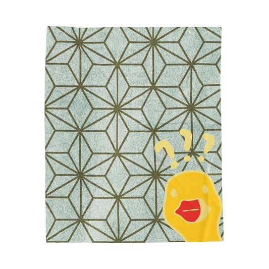Green and gold throw blanket with geometric pattern and “What the Duck” phrase styled on modern bed