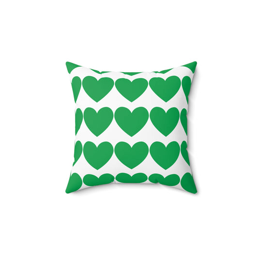 Green hearts pillow styled on a dorm bed with layered cozy blankets