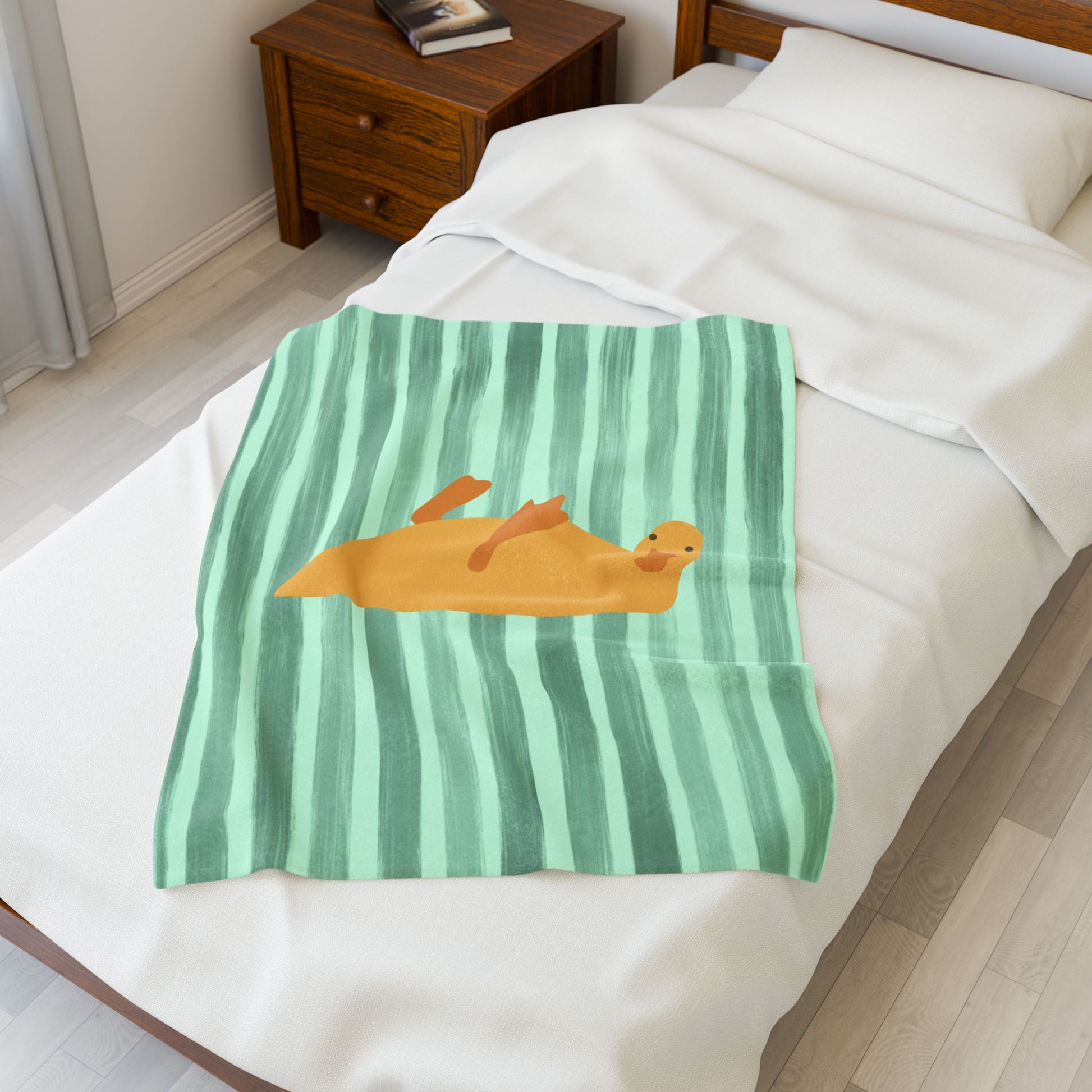 Striped green plush blanket styled on dorm bed with moody, cozy accessories