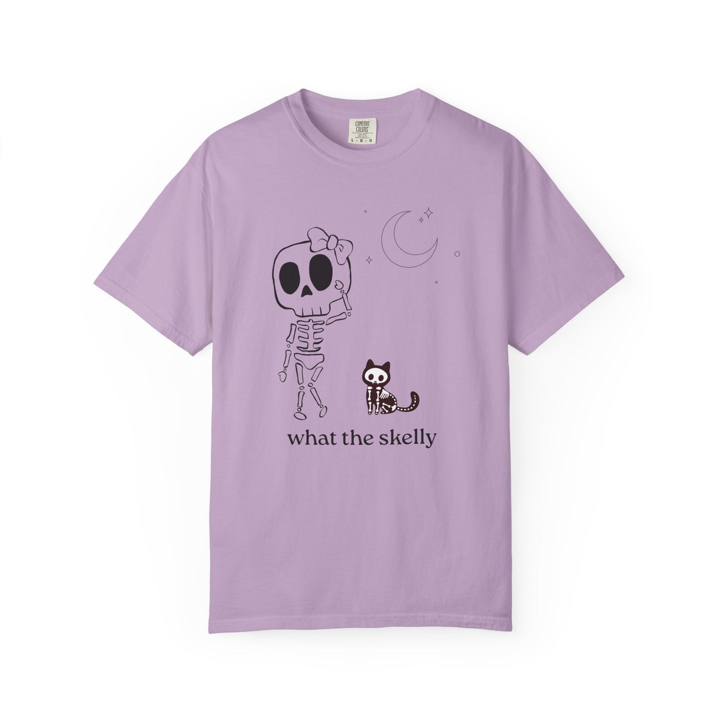 Lavender tee with “What the Skelly?” skeleton and cat illustration, styled for soft and playful spooky season fashion.
