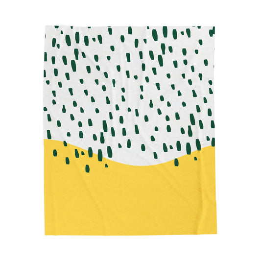 Yellow and green midcentury-style plush blanket with abstract rain pattern styled on retro bed setup