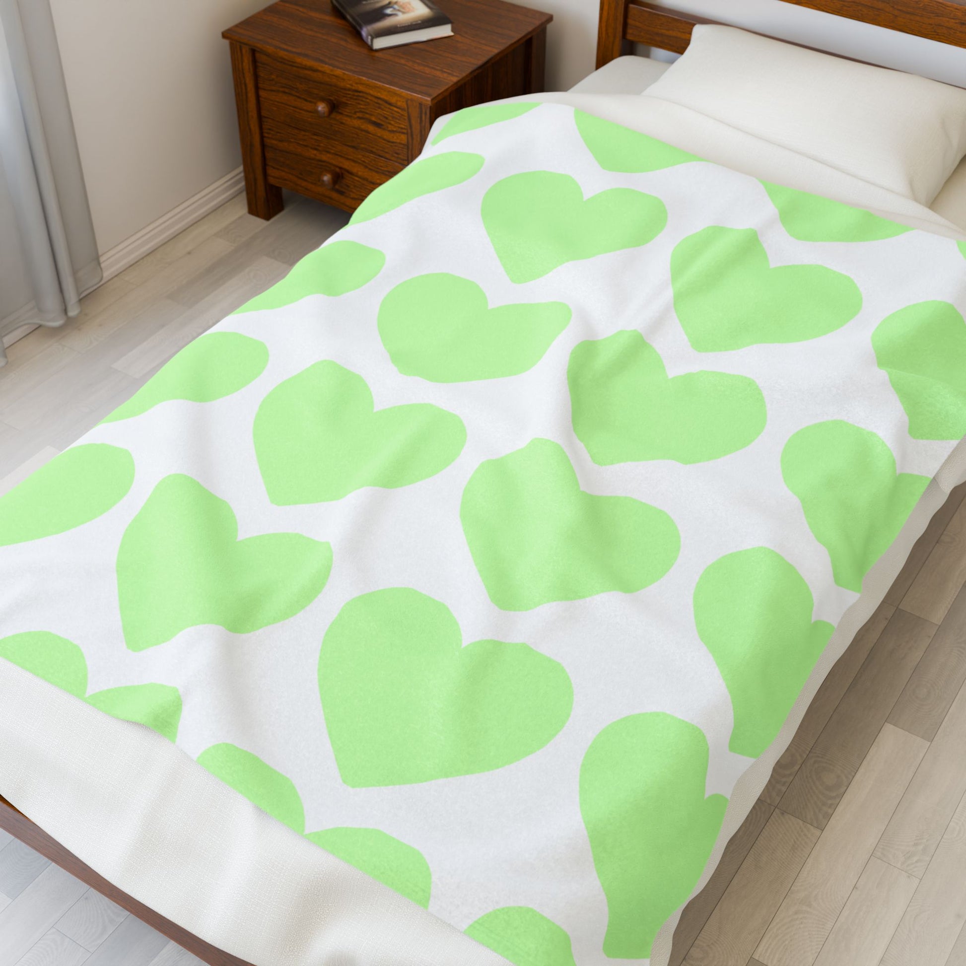 Folded mint green blanket with heart print for self-care dorm vibes
