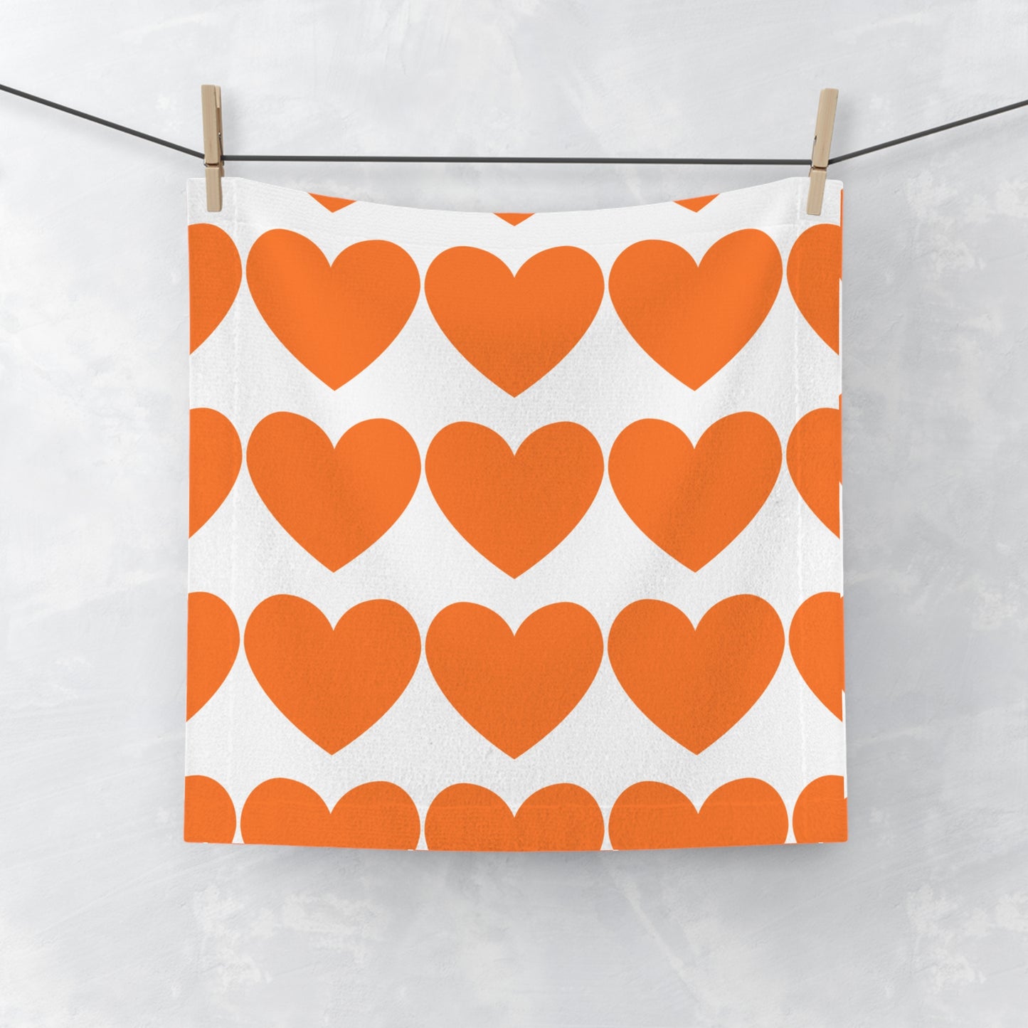 Orange hearts face towel laid flat with soft microfiber texture and playful heart pattern