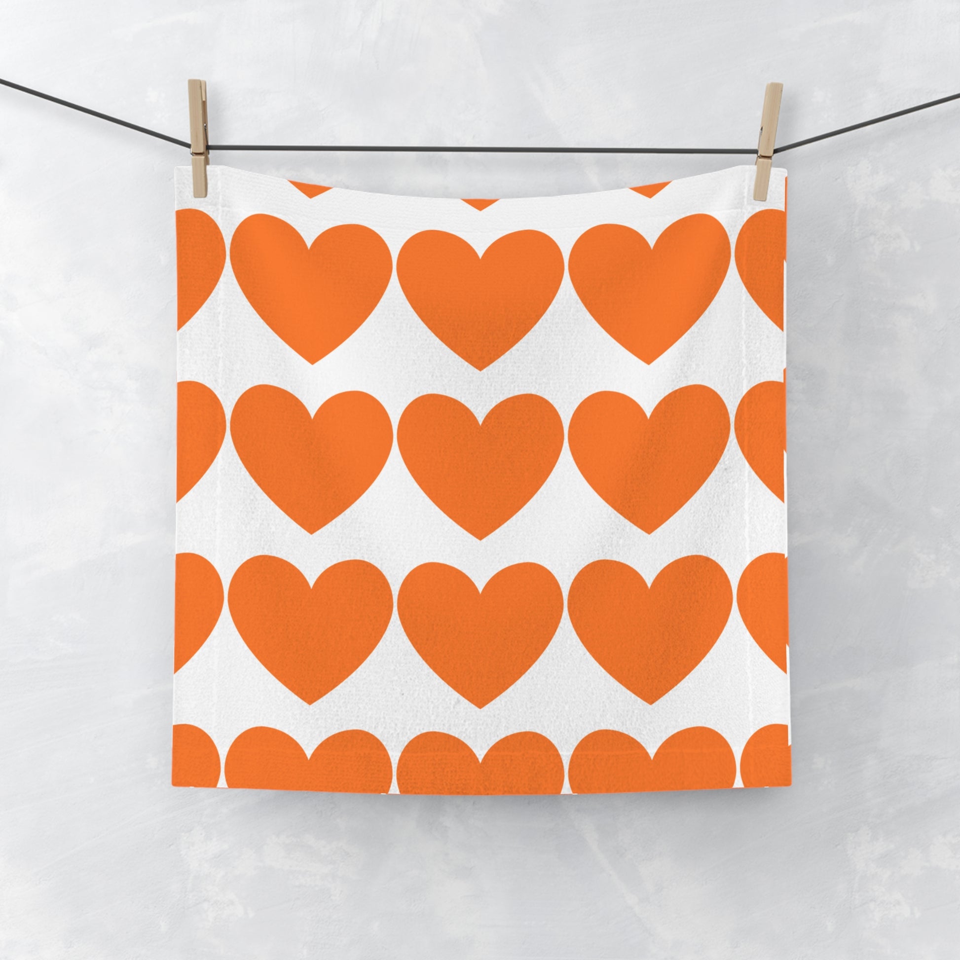 Orange hearts face towel laid flat with soft microfiber texture and playful heart pattern