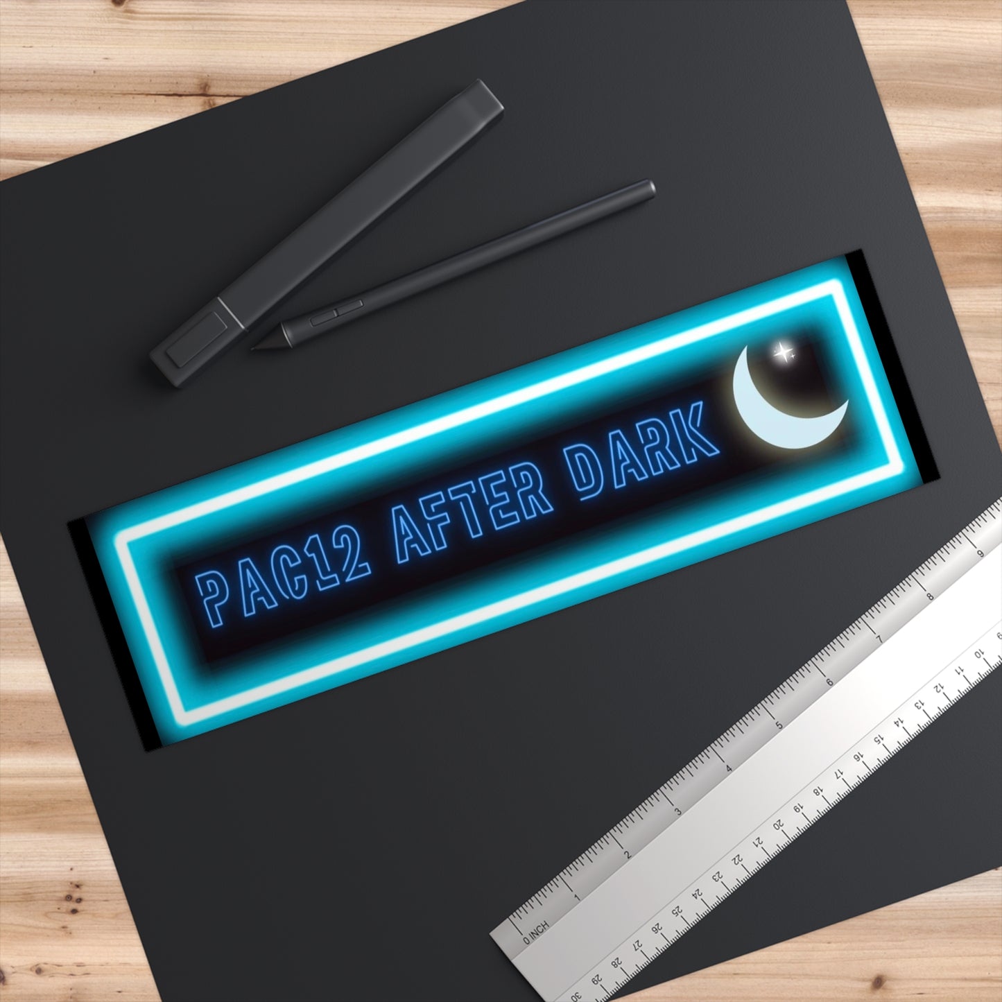 Pac-12 After Dark Bumper Sticker displayed on a desk, paying tribute to the wild and unforgettable late-night Pac-12 matchups.