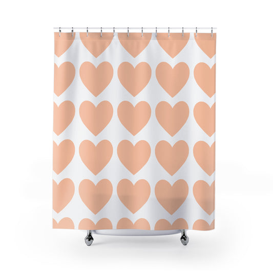 Front view of pastel orange hearts shower curtain hanging in a white and peach-toned bathroom