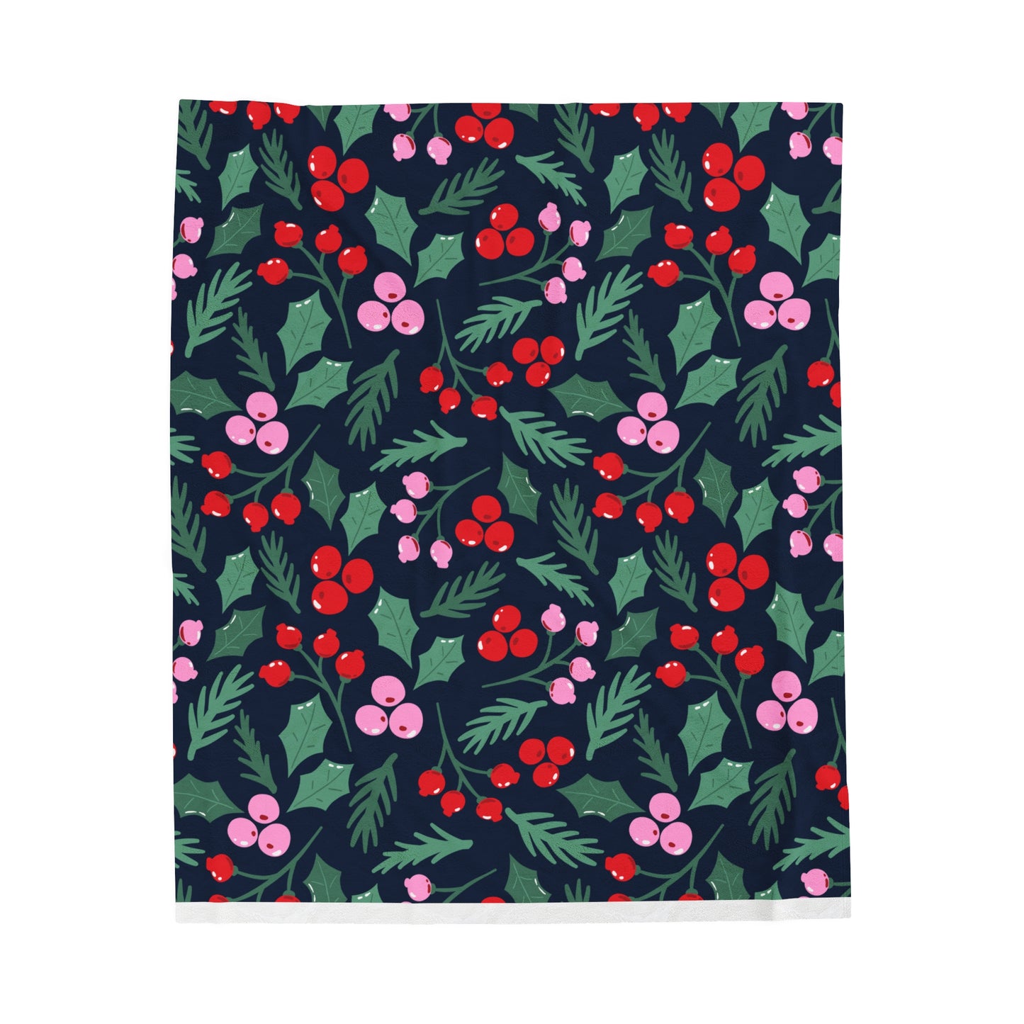 Flat lay of cozy holiday blanket with whimsical Christmas greenery pattern in pink, red, and green colors displayed on soft surface
