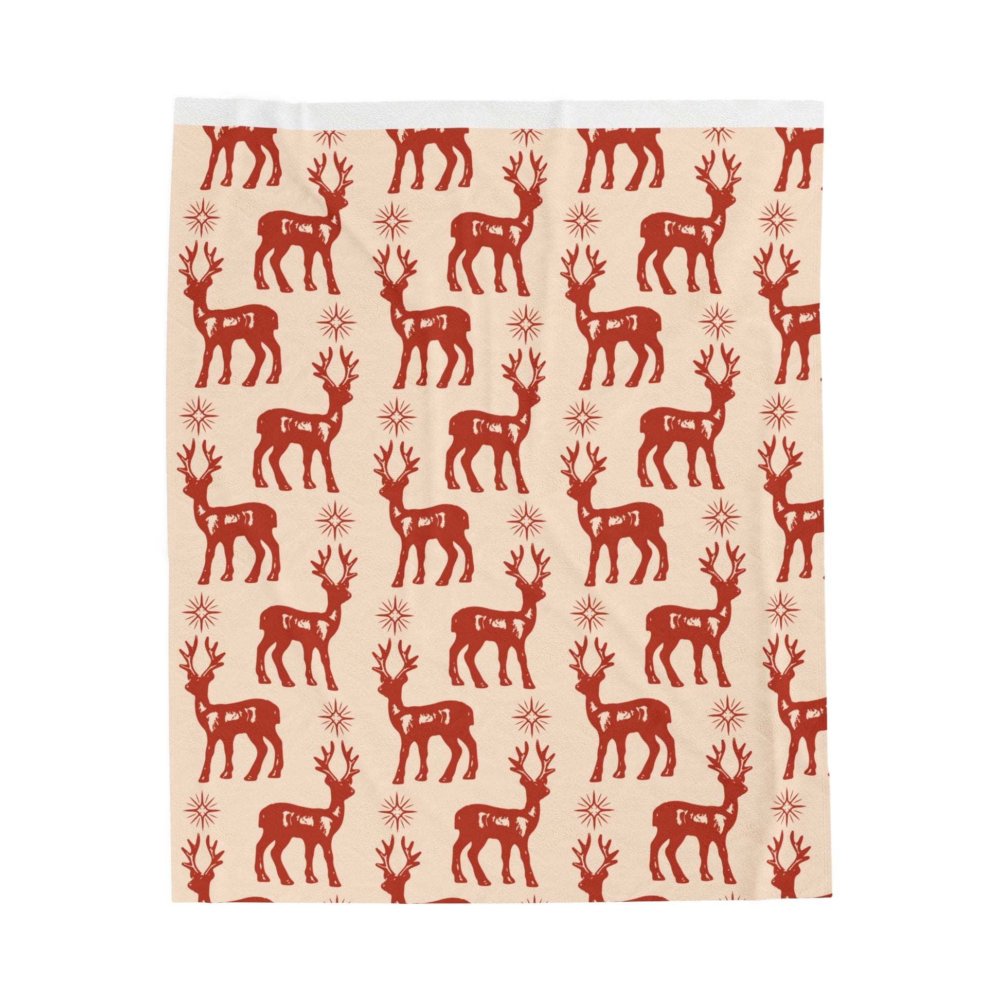 Flat lay of cozy fleece holiday blanket featuring reindeer and snowflake design on soft rustic fabric surrounded by festive props