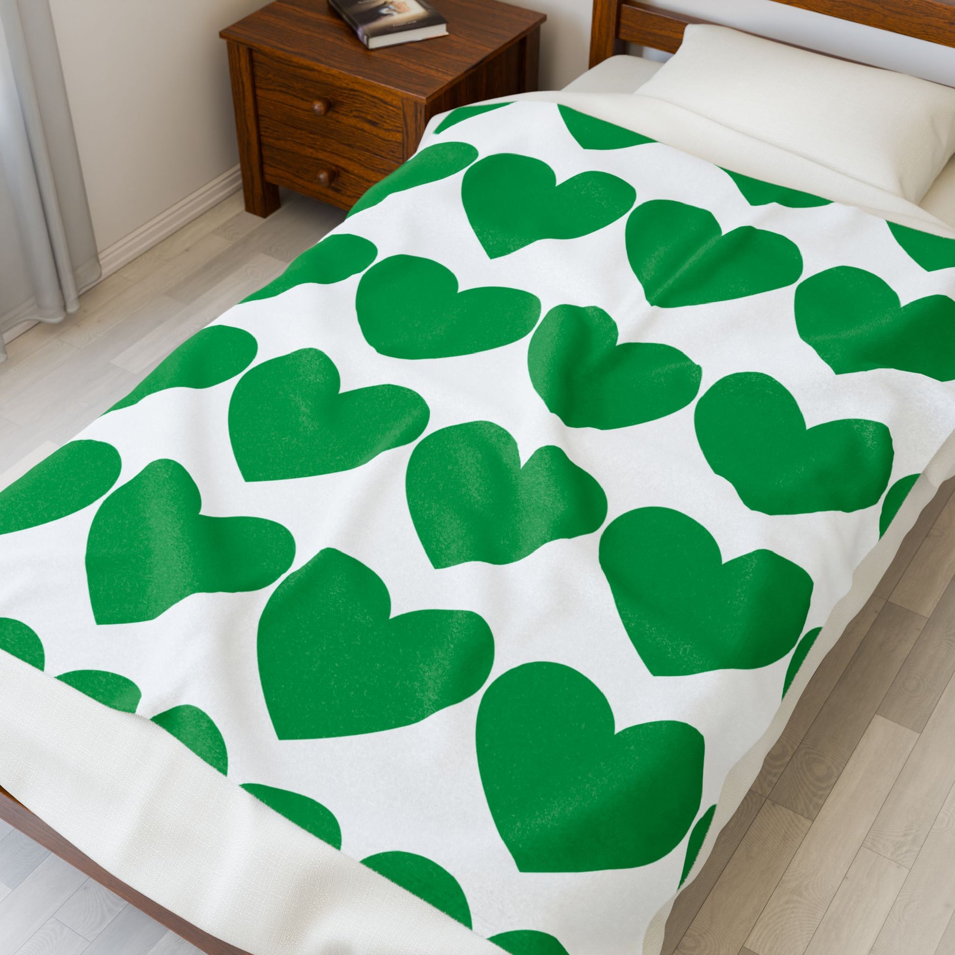 Soft fleece blanket with green heart pattern, folded for gift display
