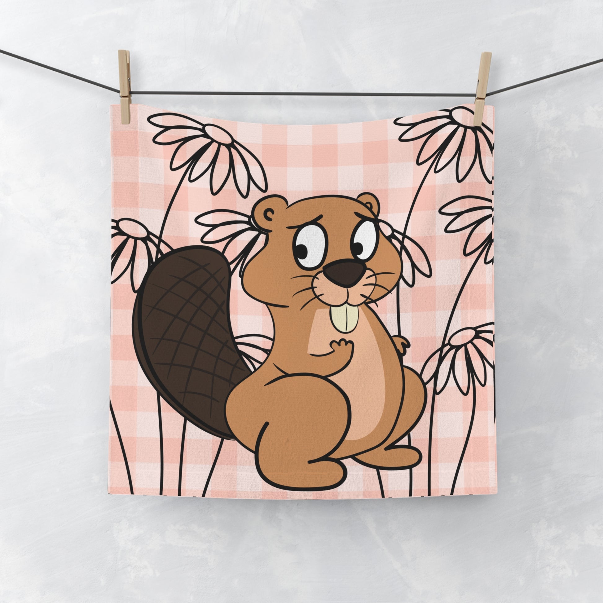 Soft orange gingham face towel with subtle beaver motif, laid flat on white surface