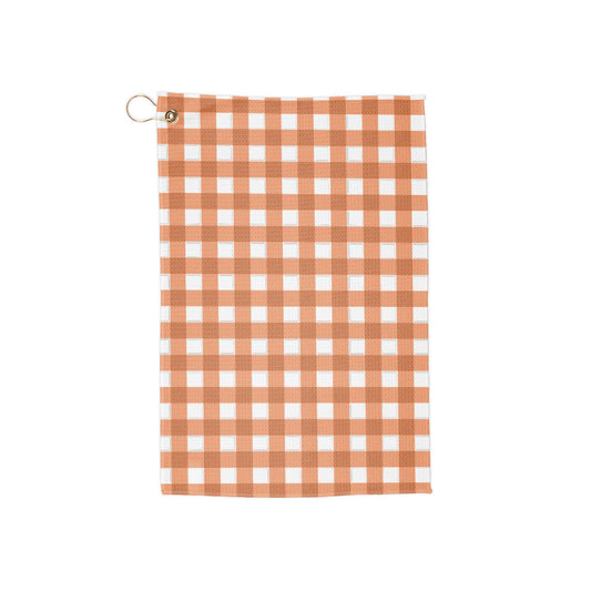 A bright orange gingham golf towel with warm, citrusy tones. A funky, retro nod to classic summer vibes on the course.