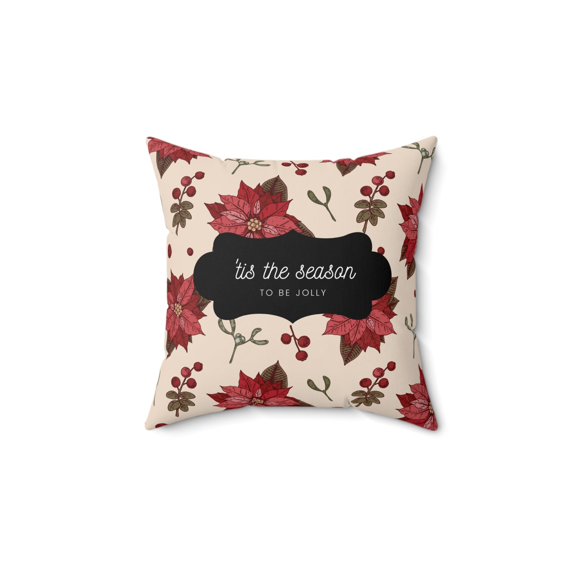 Flat lay of red floral holiday throw pillow featuring white ‘’Tis the Season’ text on soft fabric with Christmas greens