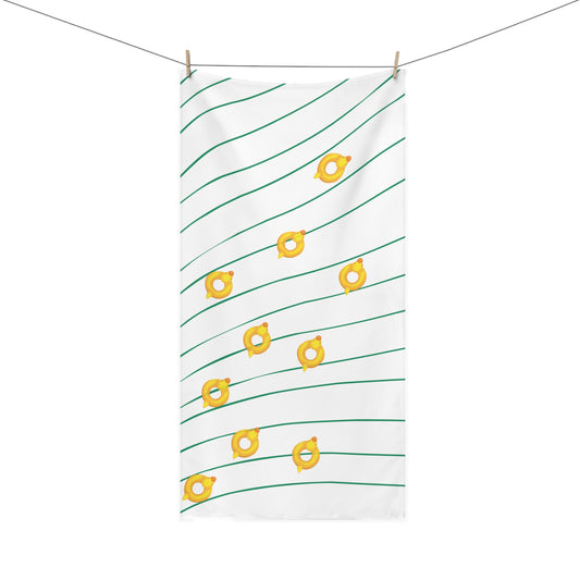 Beach towel with rubber ducky design over wavy green and gold pattern – playful and retro summer accessory